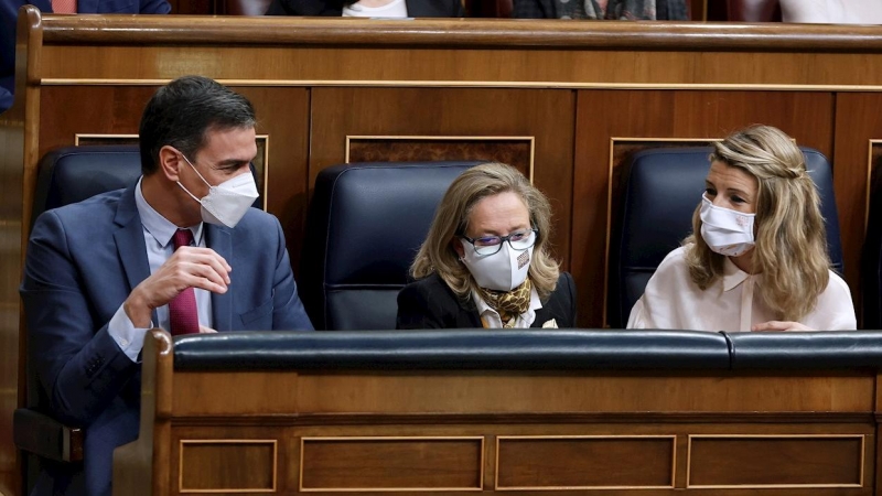 El presidente del Gobierno, Pedro Sánchez, conversa con la vicepresidenta segunda y ministra de Trabajo, Yolanda Díaz (d), en presencia de  (i) junto con la vicepresidenta primera y ministra de Asuntos Económicos, Nadia Calviño (c)  durante la sesión de c