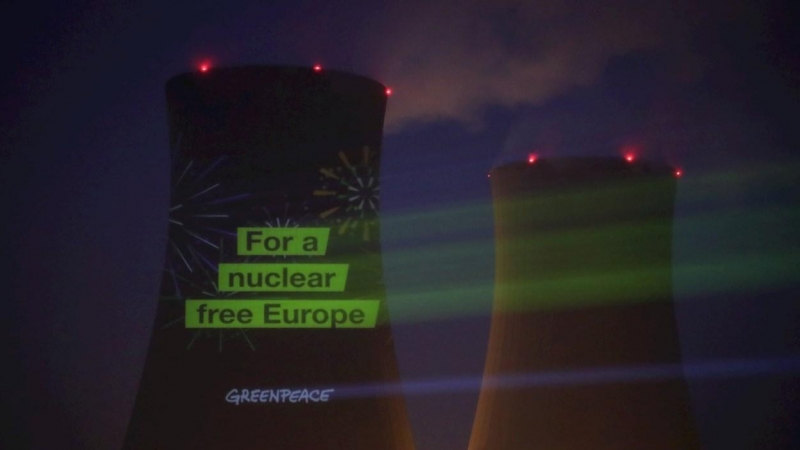 Activistas de Greenpeace proyectan el lema 'Por una Europa libre de armas nucleares' en una de las torres de refrigeración de la central nuclear de Grohnde (Kerncentrale Grohnde - KGW) en Emmerthal, norte de Alemania, el 30 de diciembre 2021.