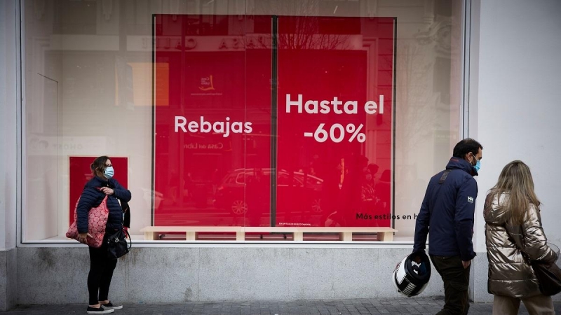 5/1/22-Varias personas pasan delante de un escaparate con cartel de rebajas en una calle comercial del centro de Madrid, a 2 de enero de 2022, en Madrid, (España).