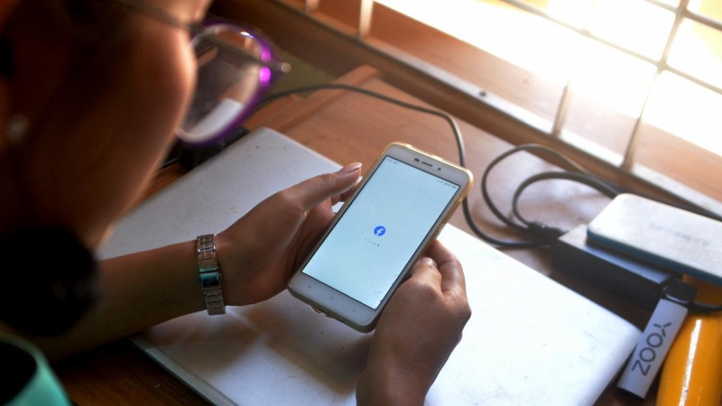 Una mujer utiliza su teléfono móvil para consultar Facebook en Naypyidaw el 16 de marzo de 2021, tras el golpe militar del 1 de febrero.