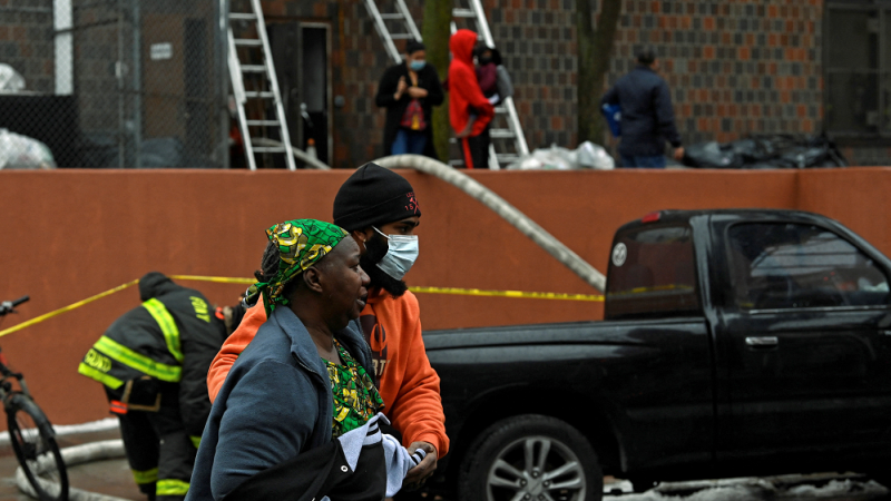 La gente camina en la escena del incendio de un edificio de apartamentos en el distrito del Bronx de la ciudad de Nueva York, EE. UU., 9 de enero de 2022. REUTERS/Lloyd Mitchell