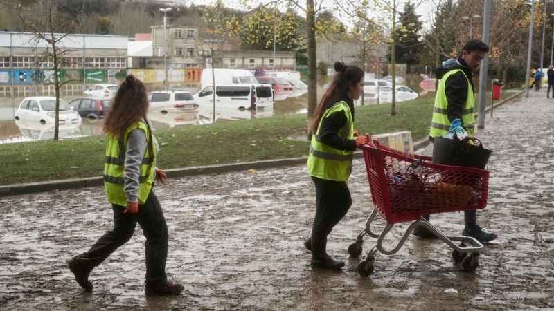 Varios vecinos recogiendo escombros y limpiando desperfectos tras la crecida del río Arga el pasado 11 de diciembre de 2021, en Burlada, Navarra.