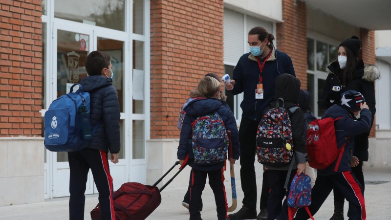 10/10/2022 Un trabajador toma la temperatura a un niño a su llegada al primer día de clase presencial tras la Navidad