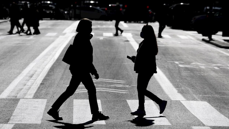 Dos personas con mascarilla se cruzan en una calle de València.