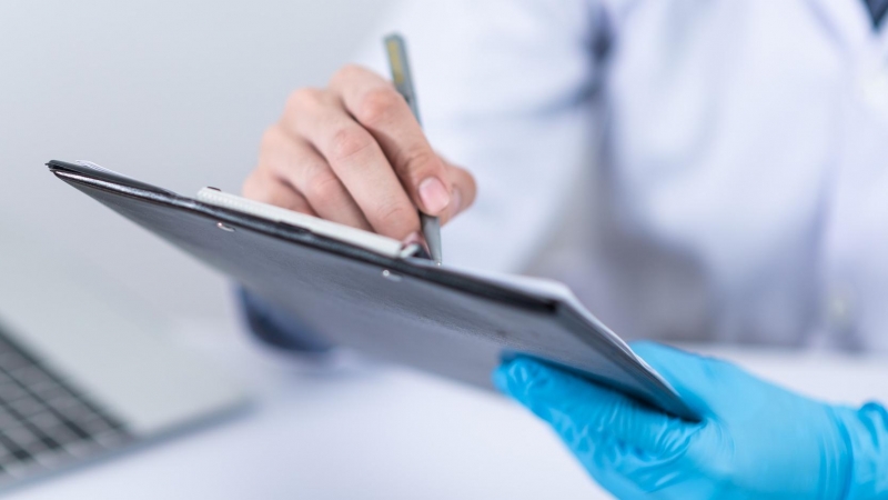 Un médico hace anotaciones en una tablet.