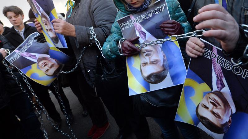 os manifestantes sostienen imágenes rotadas del presidente ucraniano Viktor Yanukovych y firmaron 'Al revés' (en ucraniano la palabra también tiene otro significado: derrocamiento y revolución) durante la acción de protesta en el Ministerio del Interior e