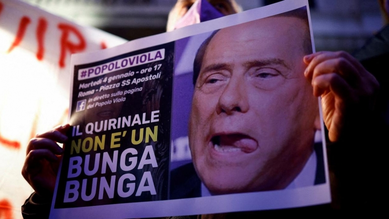 Un hombre sostiene un cartel que dice 'Quirinal [sede de la Presidencia de la República] no es un Bunga Bunga',en una manifestación por la candidatura del ex primer ministro Silvio Berlusconi a la presidencia italiana, en Roma. REUTERS/Guglielmo Mangiapan