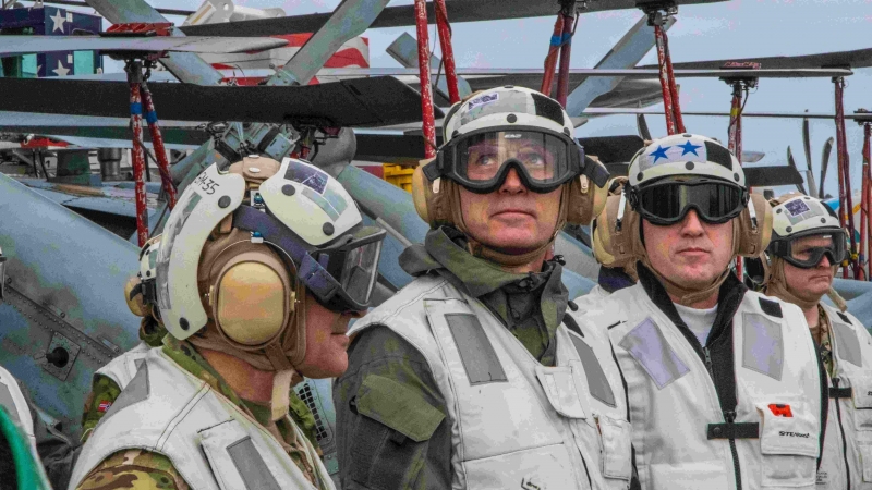 El secretario general de la OTAN, Jens Stoltenberg (C), observa un F-18 Super Hornet aterrizando en el portaaviones USS Harry S. Truman.