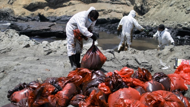 Voluntarios y pescadores recogen petróleo de la costa de Ventanilla.