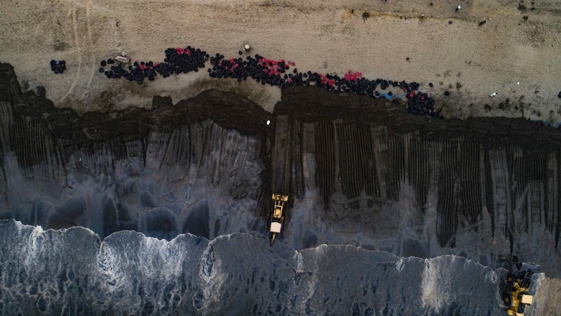 Fotografía aérea tomada desde un dron que muestra una vista general de las operaciones de limpieza de crudo en el mar de Ventanilla, en Perú.