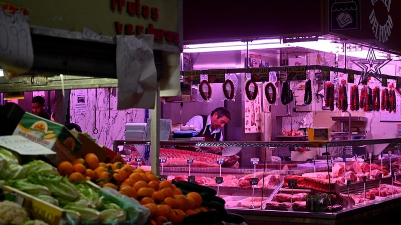 Un carnicero trabaja en su puesto en el mercado de la Cebada en Madrid.