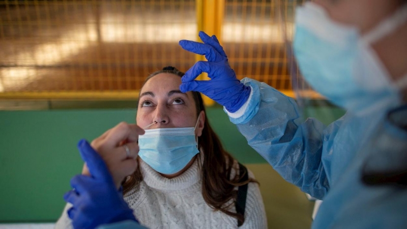 Un trabajador sanitario realiza un test de antígenos a una mujer durante el cribado poblacional celebrado en Ribadavia, en Ourense, este 27 de enero de 2022.