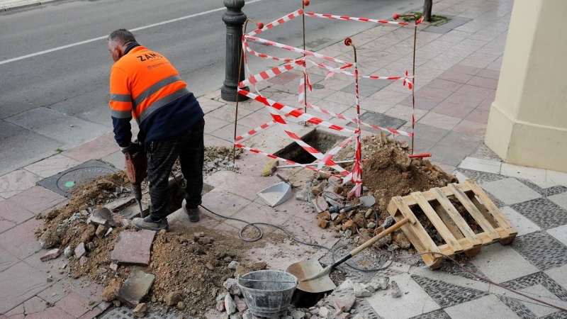 Un trabajador abre una zanja en la acera de una calle de Ronda (Málaga). REUTERS/Jon Nazca