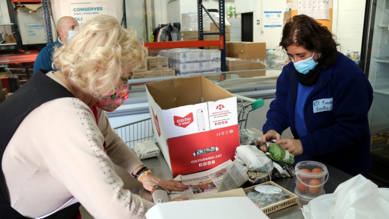 Voluntàries de la Plataforma d'Aliments de Manresa preparen lots per repartir.