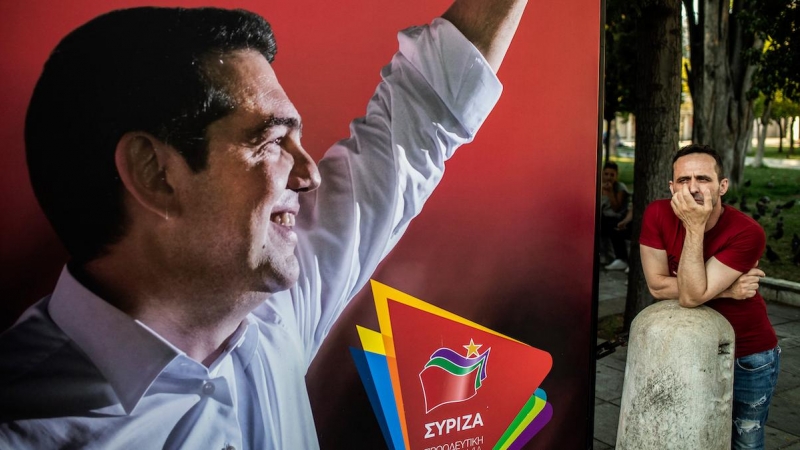 Un partidario del partido Syriza junto a un cartel electoral del primer ministro griego Alexis Tsipras, el 7 de julio de 2019, en Atenas.