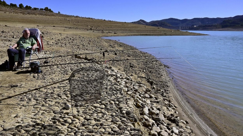 Una persona pesca en el Embalse de la Viñuela en la provincia de Málaga que oficialmente se encuentra en situación de sequía grave al haber superado el umbral de 41,5 hectómetros cúbicos.