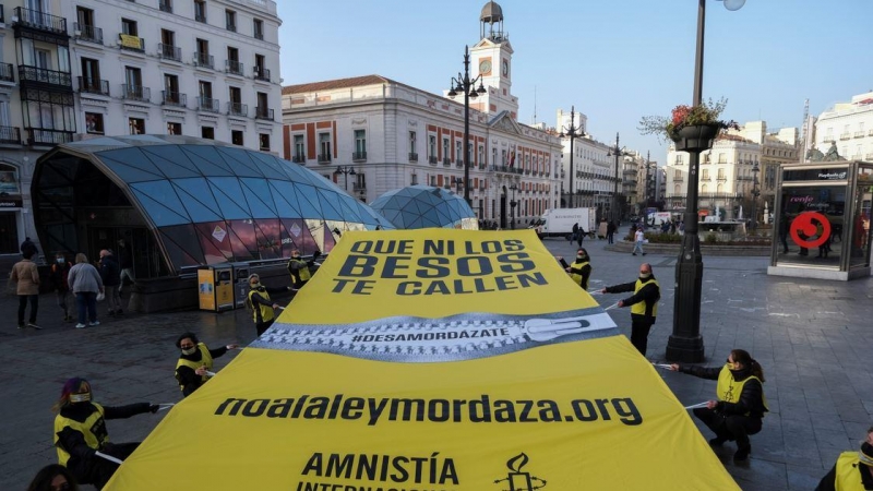 Amnistía Internacional despliega una lona en la Puerta del Sol