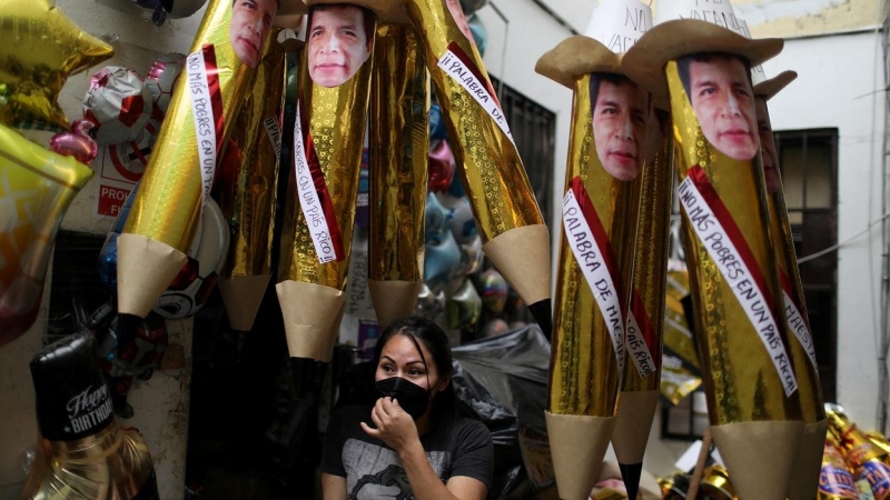 Una vendedora en un puesto callejero con piñatas que representan al presidente de Perú, Pedro Castillo, para quemarlas como tradición de Nochevieja, en una imagen de archivo de diciembre de 2021, en Lima. REUTERS/Pilar Olivares
