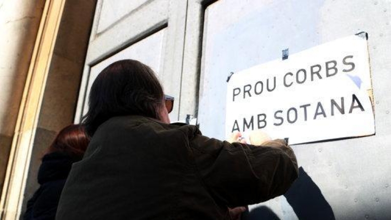 Un home enganxant cartells en la protesta per denunciar els abusos sexuals a menors d'eclesiàstics.