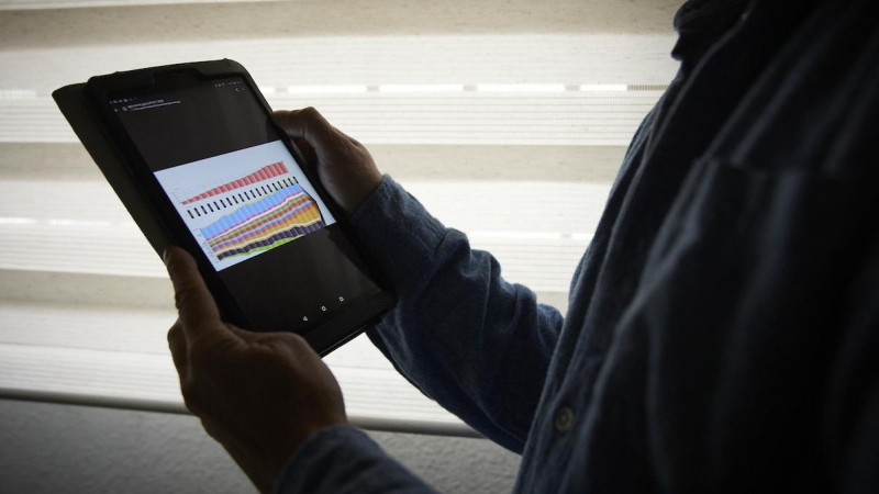 Un hombre sujeta una tablet con un gráfico, a 4 de enero de 2022, en Madrid.