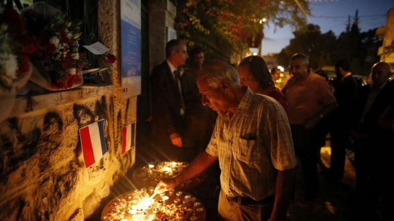 Mordechai Vanunu enciende una vela durante una vigilia en homenaje a las víctimas del ataque mortal en la ciudad de Niza en la Riviera francesa el 18 de julio de 2016.