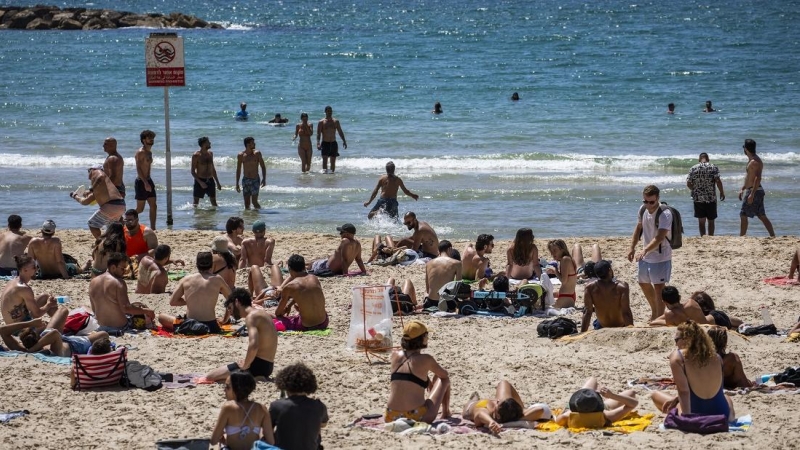 ARCHIVO. La gente juega al fútbol en la playa de Tel Aviv durante un día soleado.