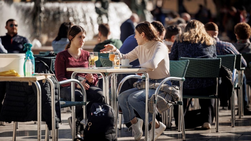 Varias personas disfrutan de un soleado día de invierno en una terraza en la ciudad de València.