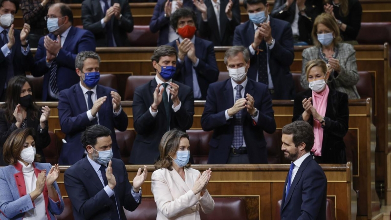 El presidente del PP, Pablo Casado, recibe los aplausos de varios diputados de su partido tras su intervención y momentos antes de abandonar el hemiciclo durante la sesión de control al Gobierno.