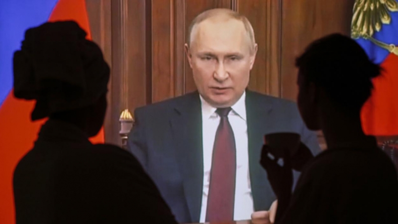Varias personas ven en Moscú el discurso televisado del presidente ruso Vladimir Putin en el que justifica su ataque a Ucrania este jueves.