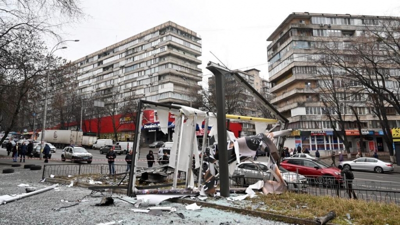 Se ve a personas fuera del área acordonada alrededor de los restos de un proyectil en una calle de Kiev el 24 de febrero de 2022.