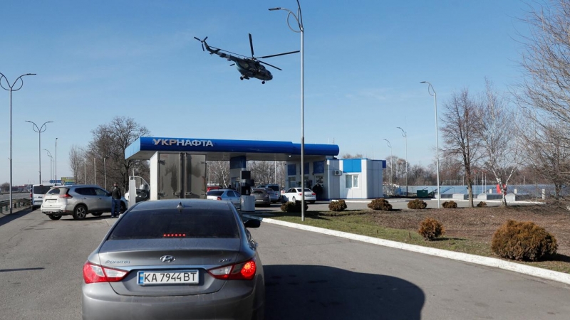 Un helicóptero militar ucraniano sobrevuela una gasolinera, después de que el presidente ruso, Vladimir Putin, autorizara una operación militar en Ucrania, en las afueras de la ciudad de Dnipro, Ucrania.