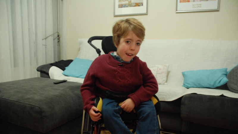 Adolfo, el pequeño de ocho años con una miopatía congénita por desproporción de fibras (una enfermedad rara con apenas casos en el mundo), posa en su vivienda de Madrid