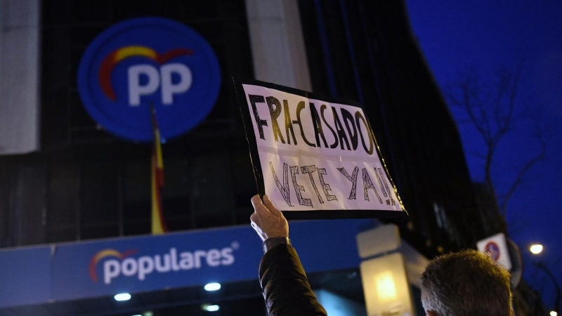 Un hombre sostiene un cartel contra Pablo Casado, durante una manifestación en apoyo a la presidenta de la Comunidad de Madrid, Isabel Díaz Ayuso, frente de la sede del Partido Popular en la calle Génova de Madrid. E.P./Fernando Sánchez