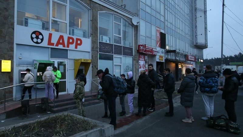 La gente hace cola en un cajero automático (ATM) en una sucursal de un banco en Kiev, el 24 de febrero de 2022, en Kiev, Ucrania