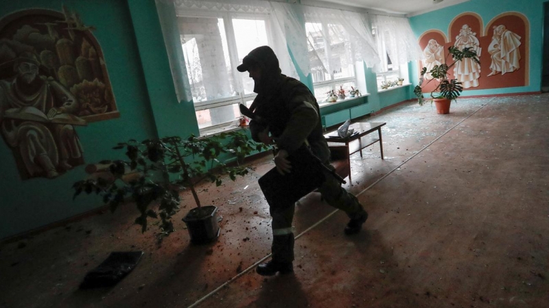 Un sodado corre dentro de un edificio escolar, que según los lugareños fue dañado por los recientes bombardeos, en la ciudad de Horlivka (Gorlovka), controlada por los separatistas prorrusos, en la región de Donetsk, Ucrania, este viernes.