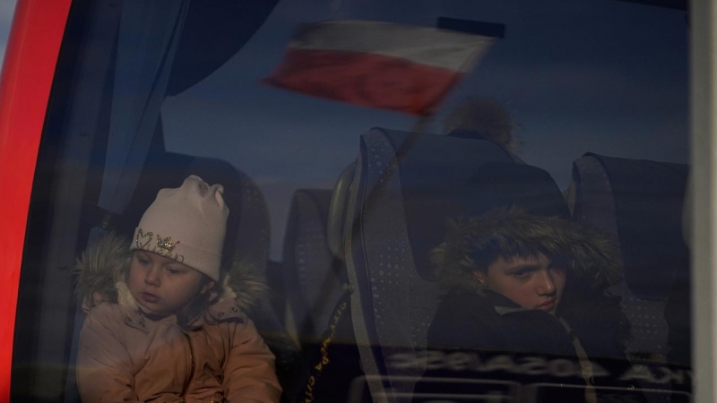 Varios niños ucranianos cruzan hacia la ciudad polaca de Medyka, en la frontera con Ucrania, junto a su madre, tras escapar de los ataques rusos en Ucrania.