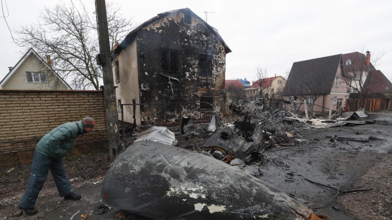 Un hombre observa los restos de un avión militar derribado durante la noche del 25 de febrero de 2022 en Kiev, Ucrania.