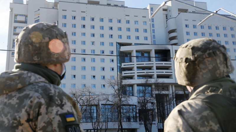 Los militares ucranianos miran un edificio residencial dañado, después de que Rusia lanzó una operación militar masiva contra Ucrania, en Kiev, Ucrania, el 26 de febrero.