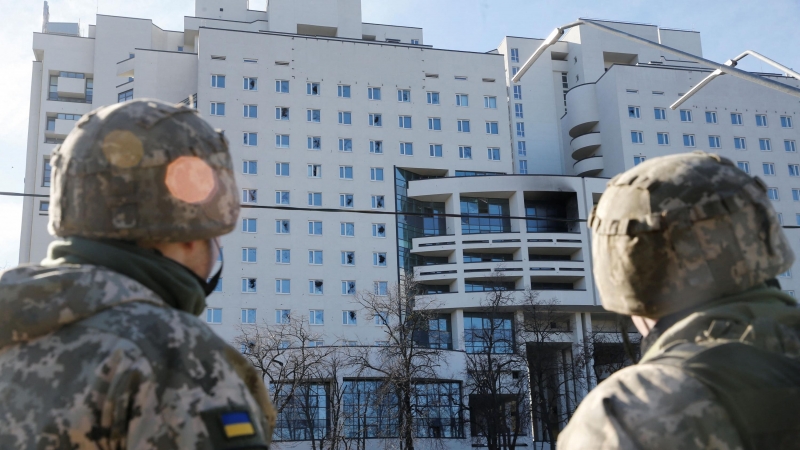 Los militares ucranianos miran un edificio residencial dañado, después de que Rusia lanzó una operación militar masiva contra Ucrania, en Kiev, Ucrania, el 26 de febrero.