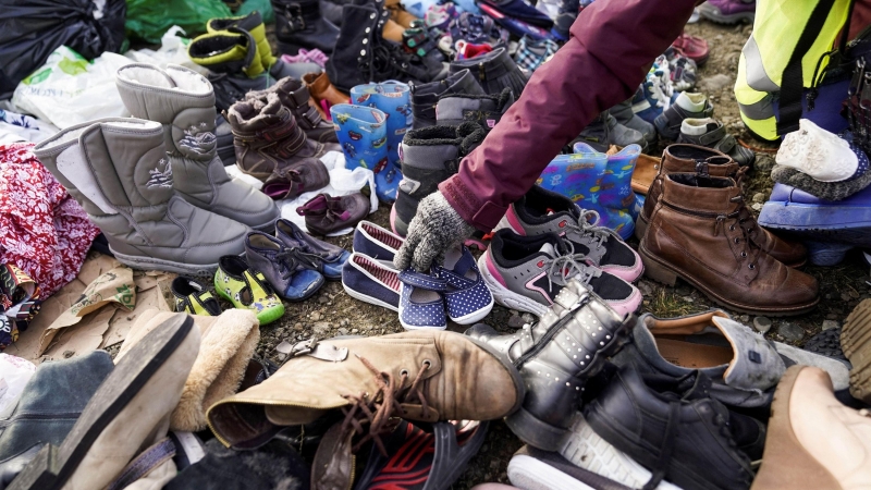 Un trabajador humanitario clasifica los zapatos donados para quienes huyen de la invasión rusa en Ucrania y cruzan la frontera, en Medyka, Polonia, el 27 de febrero de 2022.
