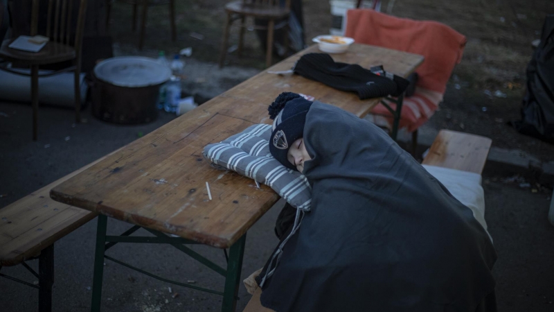 Un niño duerme sobre la mesa mientras las personas que huyen de Ucrania llegan a Eslovaquia, en el cruce fronterizo de Vysne Nemecke, Eslovaquia, el 27 de febrero de 2022.