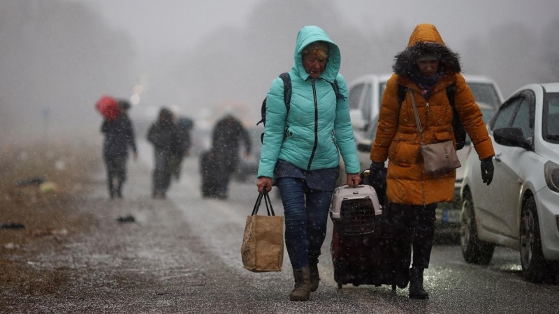 Las personas que huyen de la invasión rusa de Ucrania se dirigen hacia el cruce fronterizo de Shehyni, Polonia.
