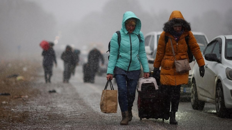 Las personas que huyen de la invasión rusa de Ucrania se dirigen hacia el cruce fronterizo de Shehyni, Polonia.