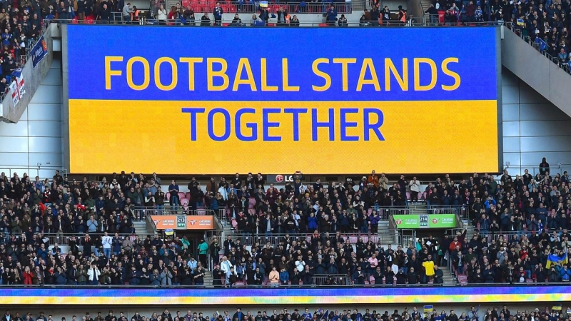 El eslogan 'El fútbol se mantiene unido' se ve en una pantalla gigante antes de la final de la Copa Carabao inglesa entre el Chelsea FC y el Liverpool FC en Wembley en Londres, Gran Bretaña, el 27 de febrero de 2022.