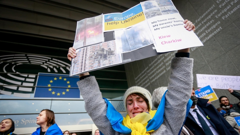 Una mujer sostiene una pancarta a favor de Ucrania a las afueras del Parlamento Europeo, que este 1 de marzo de 2022 ha tenido una sesión extraordinaria para debatir sobre la invasión de Rusia a Ucrania.