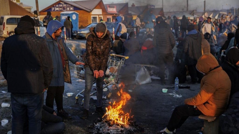 Varias personas procedentes de Ucrania, en su mayoría de nacionalidad no ucraniana, tratan de combatir el frio en las inmediaciones de la frontera con Ucrania en Medyka (Polonia).