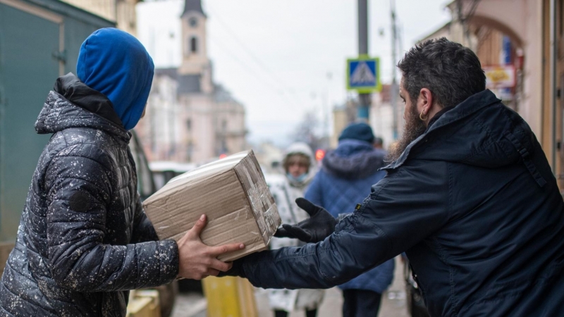 Varias personas descargan un camión con donaciones para un centro de refugiados ucranianos, a 4 de marzo de 2022, en el oeste de Ucrania.