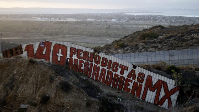 Una pintura que dice '140 periodistas asesinados en MX' en una sección de la valla fronteriza entre EE. UU. y México en Tijuana, en el estado de Baja California, México, en 2018