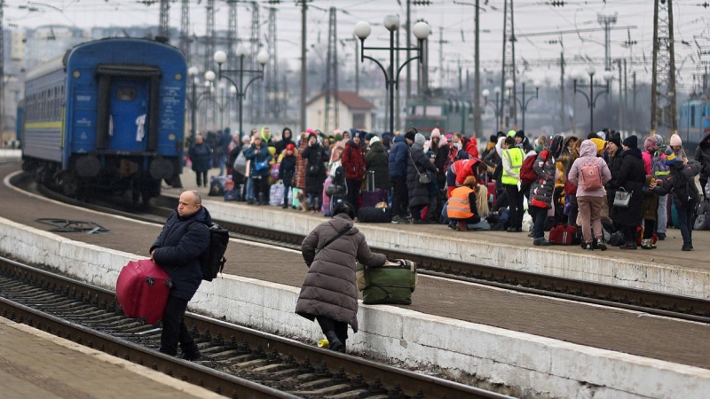 Refugiados ucranianos cruzan las vías del tren en la estación de Lviv.