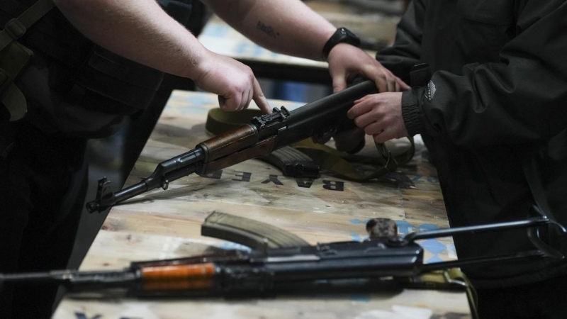 Instructores de armamento enseñan a manejar armas de guerra a civiles ucranianos, para la defensa de la ciudad ucraniana de Lviv (Oeste de Ucrania), este sábado en la Filmoteca de la ciudad.- EFE / Borja Sánchez Trillo